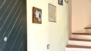 A staircase with a handrail, a door with diagonal lines, and two framed artworks on the wall. - M328 - Marcelli, two-room apartment with sea view (Marcelli)