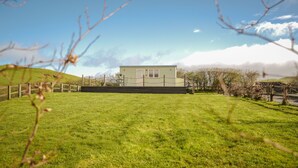 A house with a fenced yard, a clear sky, and a distant mountain.
