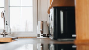 A modern kitchen with a stainless steel sink, a coffee machine, and a black microwave. - Hillside View Shepherds Hut Sleeps 2 (Rhayader)
