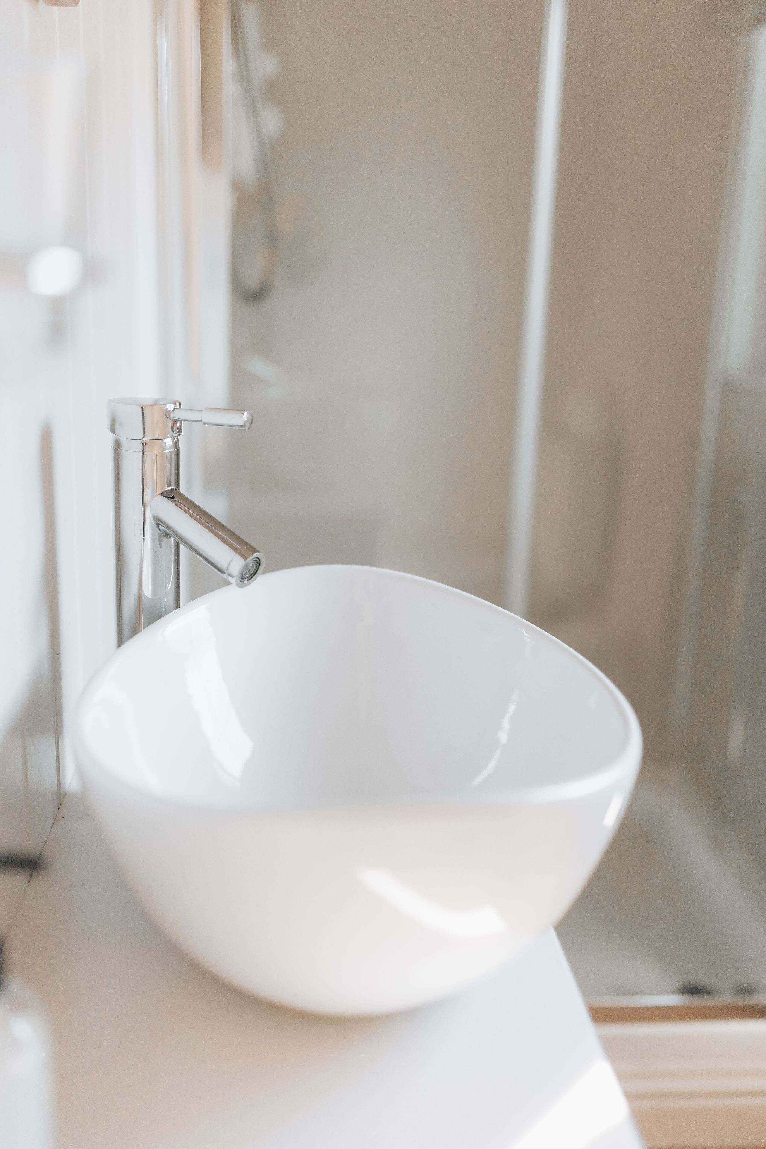 A white ceramic sink with a chrome faucet in a bathroom.