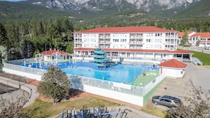 Un hotel con piscina, uno scivolo acquatico e vista sulle montagne.