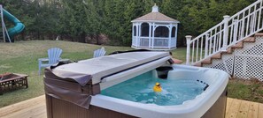 A hot tub with a duck floating in it, surrounded by a deck, a gazebo, and a slide. - Luxury Home with Sauna, Hot Tubs, Game Room, Short Walk to Lake, Outdoor Pool (Albrightsville)