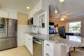 A modern kitchen with stainless steel appliances, a granite countertop, and a built-in microwave. - Waterfront Oasis! Heated Pool, 2 Docks & Boat Lift (Palmetto)