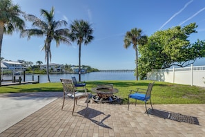 A waterfront patio with outdoor seating, a fire pit, and a view of the water. - Waterfront Oasis! Heated Pool, 2 Docks & Boat Lift (Palmetto)