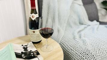 Une bouteille de vin du domaine Faiveley et un verre de vin rouge sur une table en bois.
