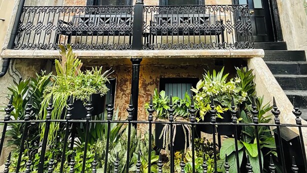 A multi-story building with a balcony, potted plants, and a metal railing. - Live like a local in the heart of Surry Hills (Surry Hills)
