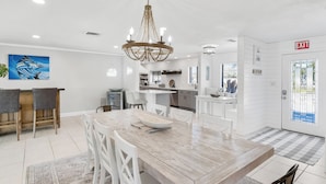 A modern kitchen with white cabinetry, a central island, and a chandelier.