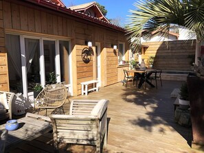 A wooden deck with outdoor furniture, including a table and chairs, and a bench. - A charming Arcachonnaise home with all the comforts (ARCACHON)