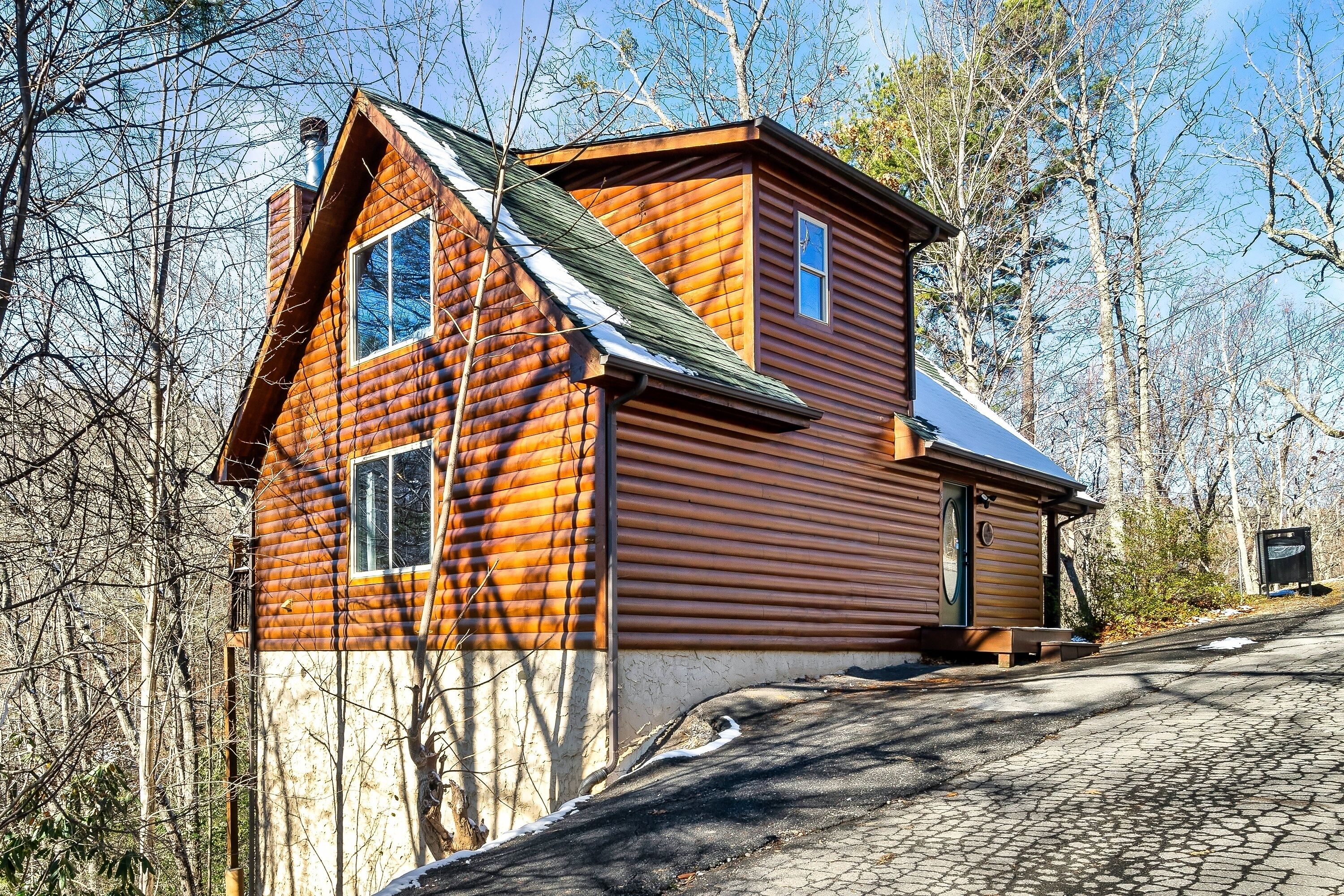 A log cabin with a steep roof, a chimney, and a small porch.