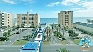 A coastal hotel with multiple high-rise buildings, a parking area, and a view of the ocean. - Lazy River and Indoor Pool Sleeps 8 CT605 (Gulf Shores)