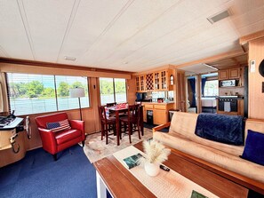 Een compact camperinterieur met een eethoek, een keuken en een zithoek.