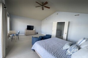 Ein Schlafzimmer mit einem Bett, einem Schreibtisch, einem Fernseher und einem Kleiderschrank.