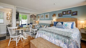 A bedroom with a bed, a desk, chairs, and a window. - Cozy Mid-Cape Studio Steps to the Beach & Pool (Dennis Port)
