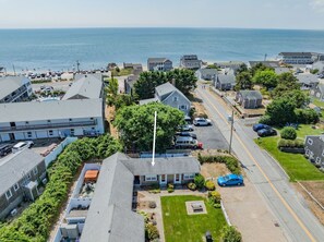 Ein Küstenwohngebiet mit Häusern, freiem Blick auf das Meer und einer Straße, die zum Strand führt.