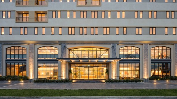 A multi-story hotel with a symmetrical facade, large windows, and a central entrance with a glass canopy. - HIIVE by fusion Binh Duong - VSIP 1 (Ho Chi Minh City)