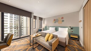 A hotel room with two beds, a sofa, a desk, and a chair. - HIIVE by fusion Binh Duong - VSIP 1 (Ho Chi Minh City)