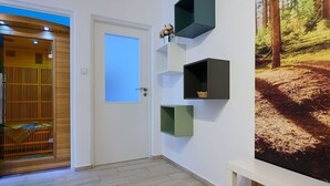 A hallway with a wooden door, a wall-mounted shelf with a basket, and a large forest-themed wall mural. - Lovely apartment for 6 guests with WIFI, TV and balcony (Jilemnice)