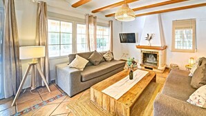 Una sala de estar con sofá, mesa de centro y chimenea.