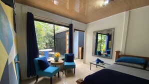 Une chambre à coucher avec un lit, deux chaises, une petite table et une fenêtre.