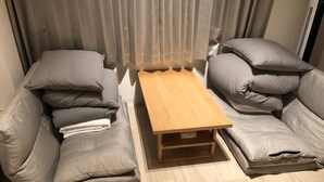 A room with two grey sofas, a wooden coffee table, and a window with curtains. - Shinosaka 1 min  (Osaka)