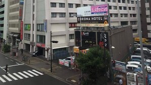 A multi-story building with a prominent red and white sign for Igin, a Corona Hotel sign, and various other commercial signs. - Shinosaka 1 min  (Osaka)