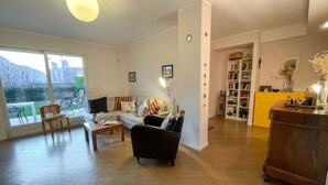 A spacious living room with a sofa, chairs, a coffee table, and a bookshelf. - Beautiful apartment for 6 people with WIFI, TV and patio (Lecco)