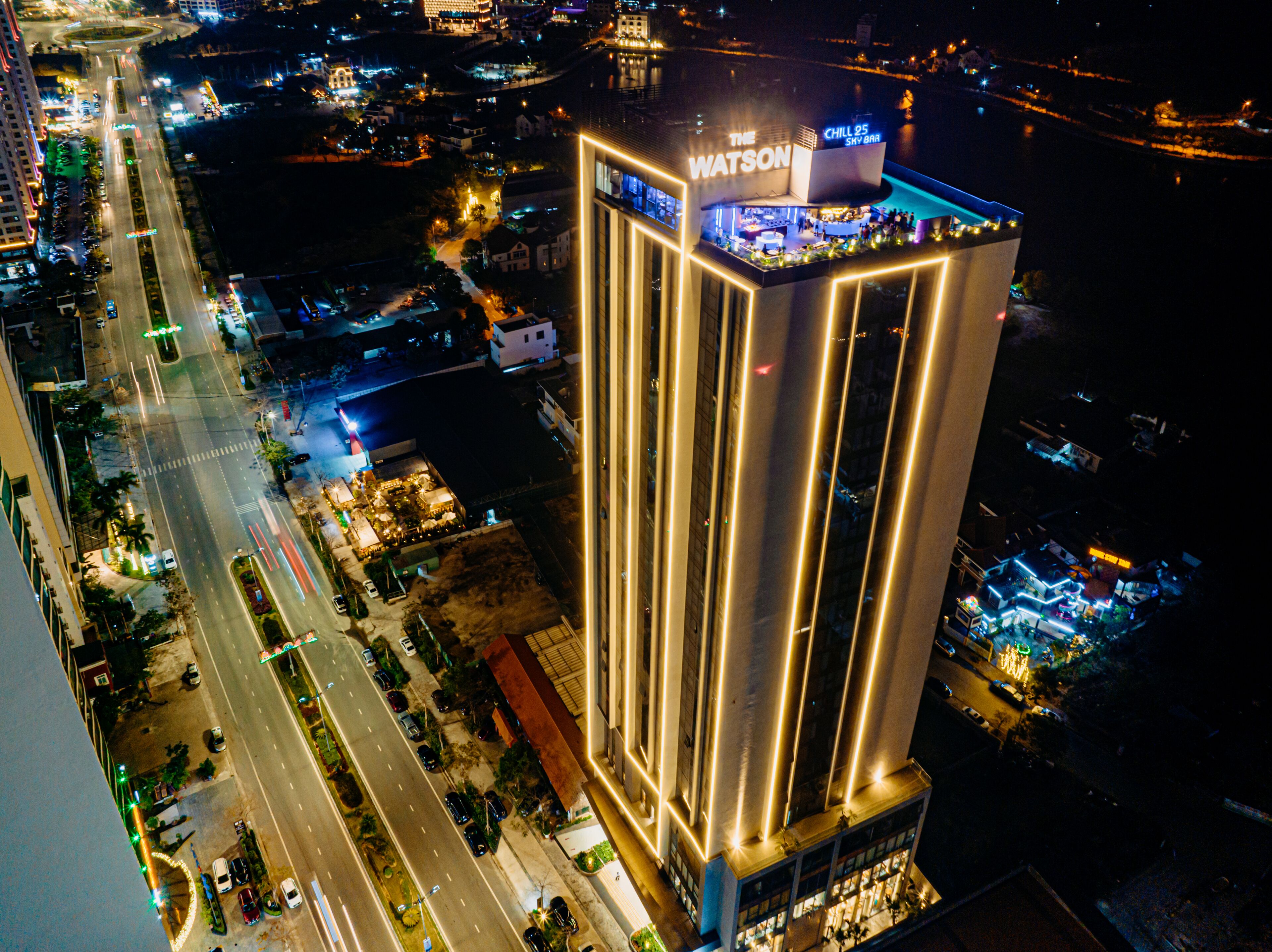 A high-rise hotel with a prominent sign reading "The Watson" and "Chill 25 Sky Bar".