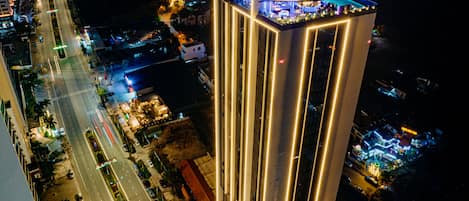 A high-rise hotel with a prominent sign reading "The Watson" and "Chill 25 Sky Bar".