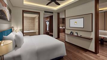 A modern hotel room with a large bed, a ceiling fan, a mounted TV, and a wooden floor.
