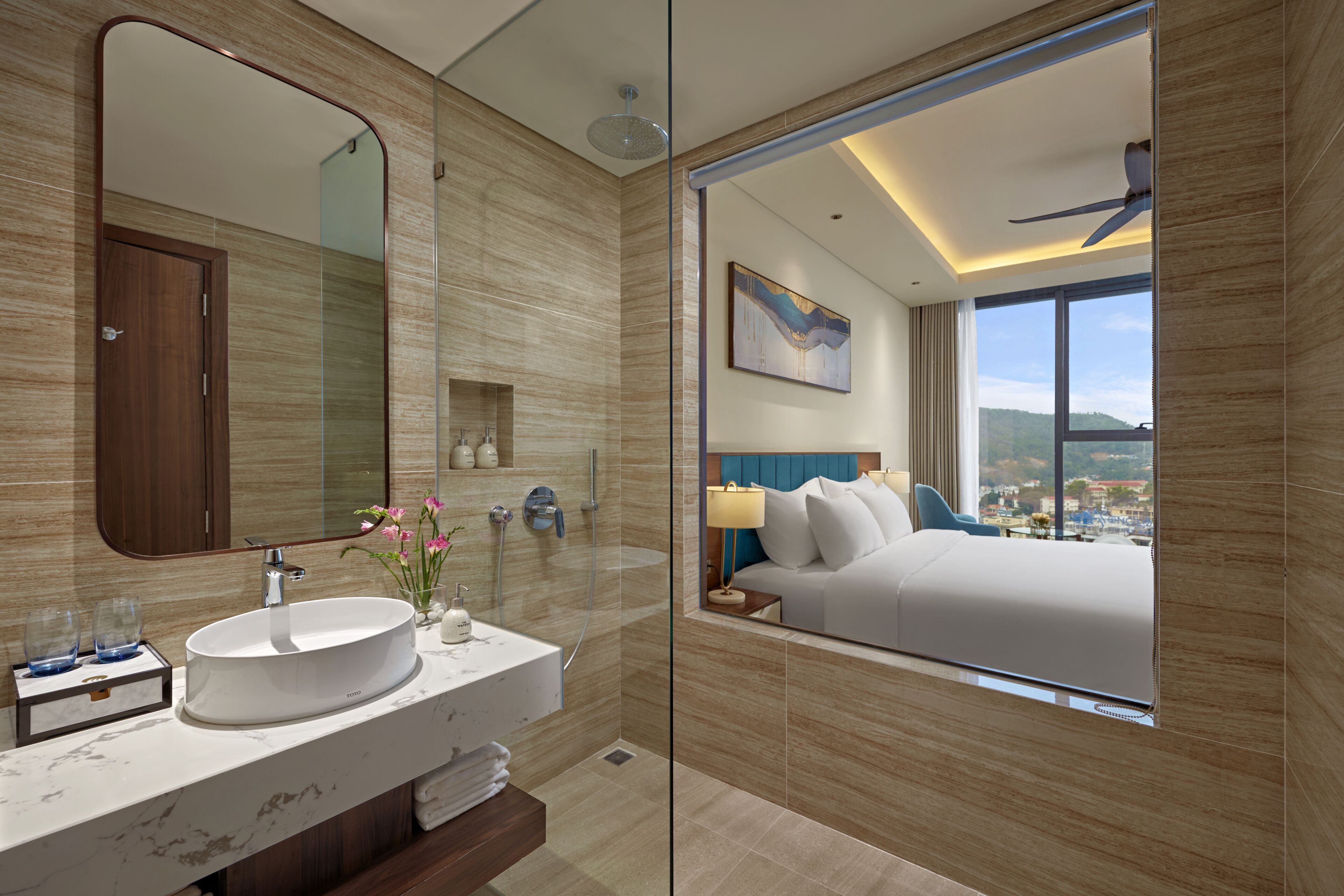 A modern bathroom with a large mirror, a round sink, and a shower.