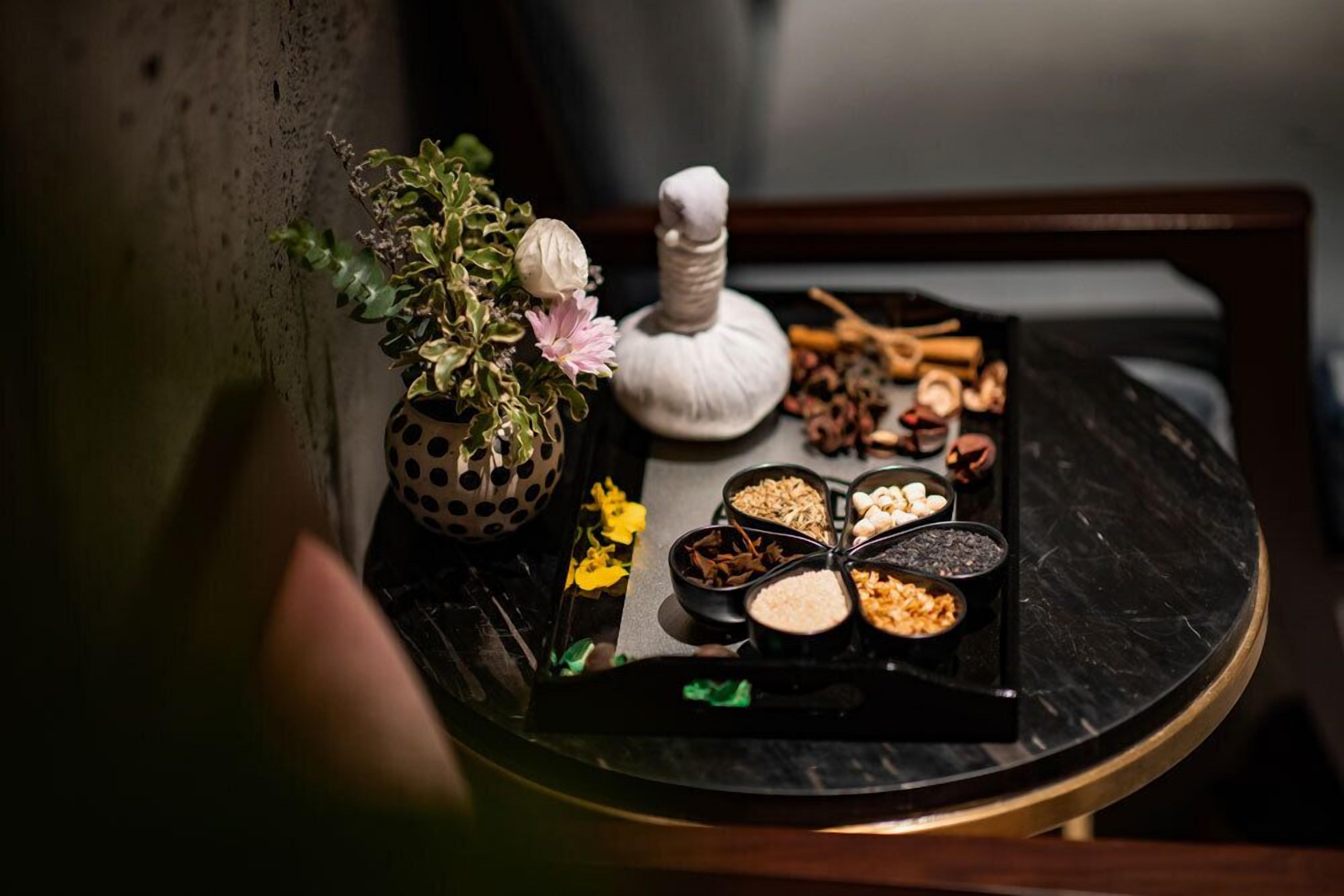Una mesa con una variedad de especias y una pequeña planta en maceta.