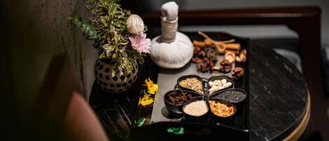 Una mesa con una variedad de especias y una pequeña planta en maceta.