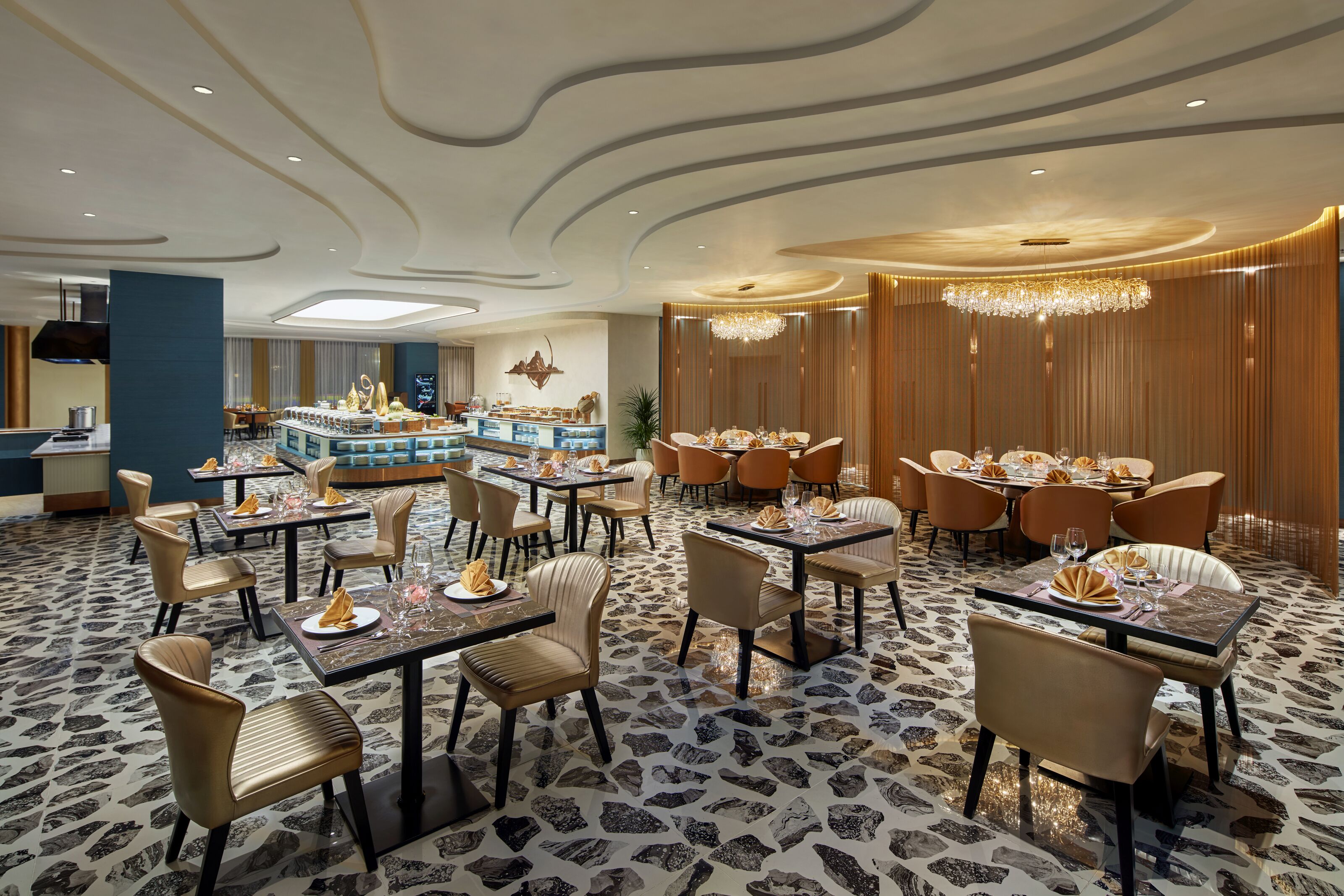 A spacious dining area with multiple tables and chairs, a central buffet, and a modern ceiling design.