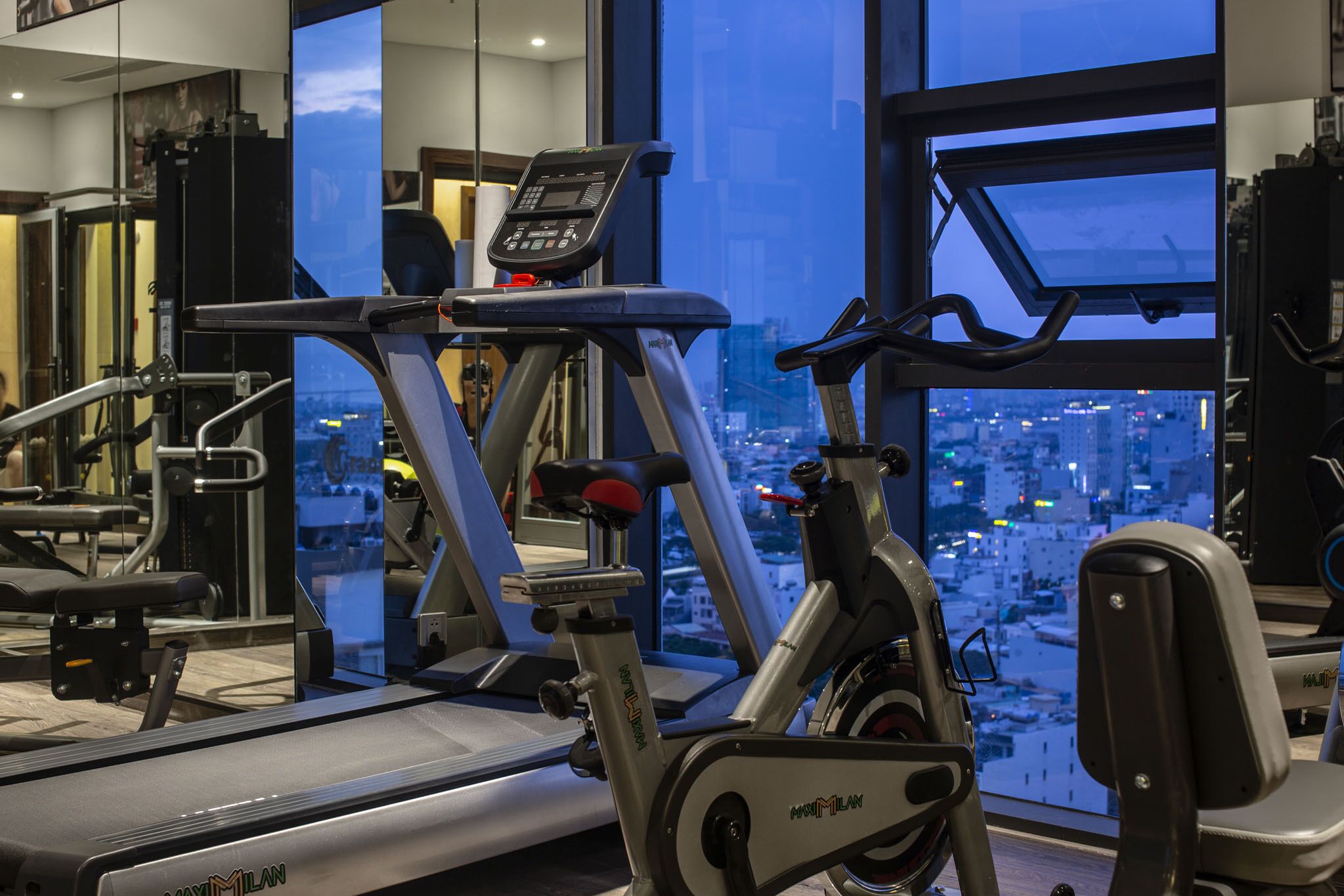 A gym with a treadmill, stationary bike, and various exercise machines.