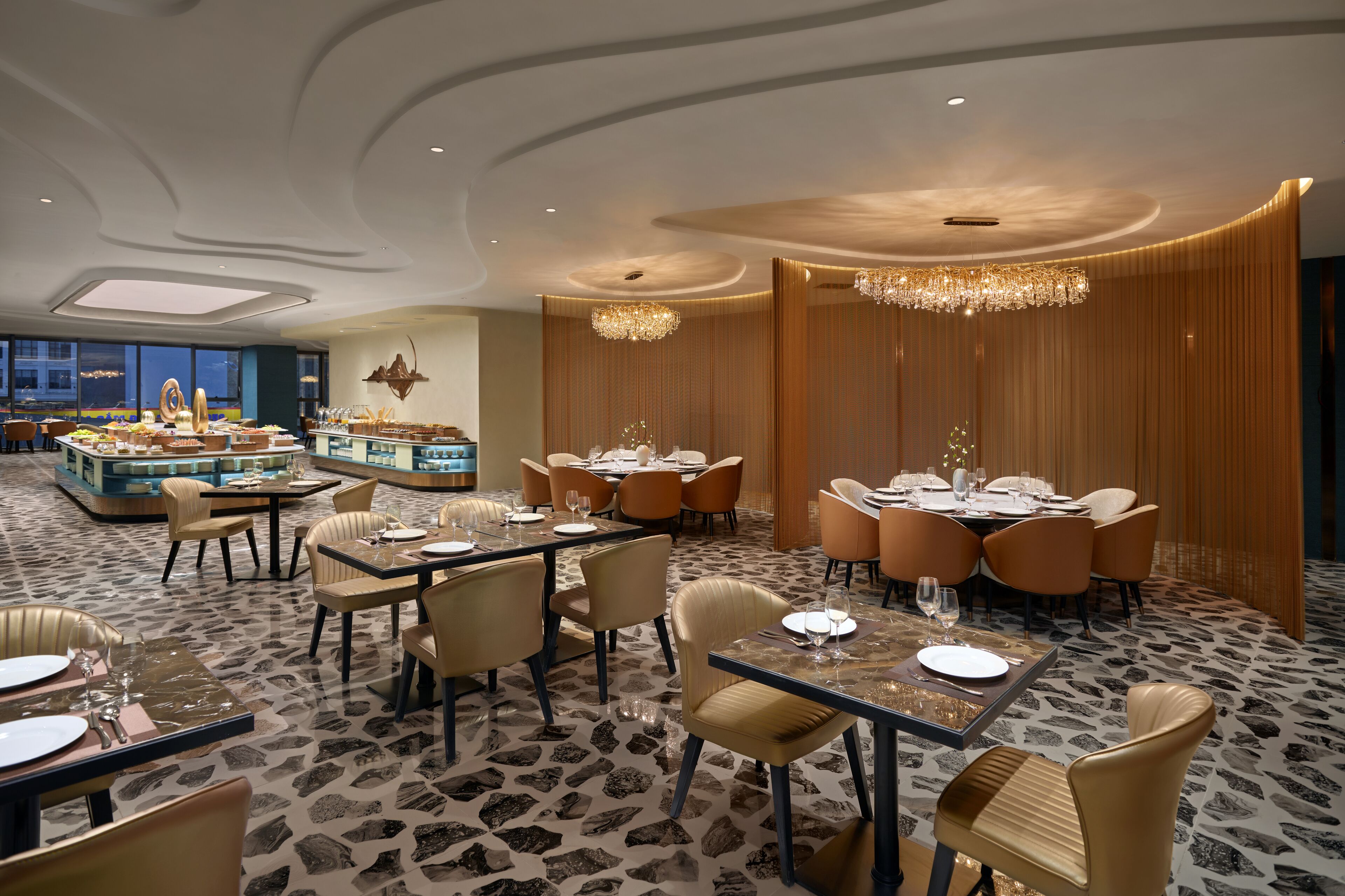 A modern dining area with round tables, cushioned chairs, and a central buffet.