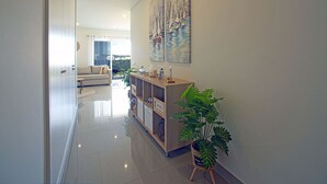 A modern living room with a sofa, a coffee table, and a potted plant. - Nice apartment for 4 people with A/C, WIFI, pool, TV and balcony (Portimão)