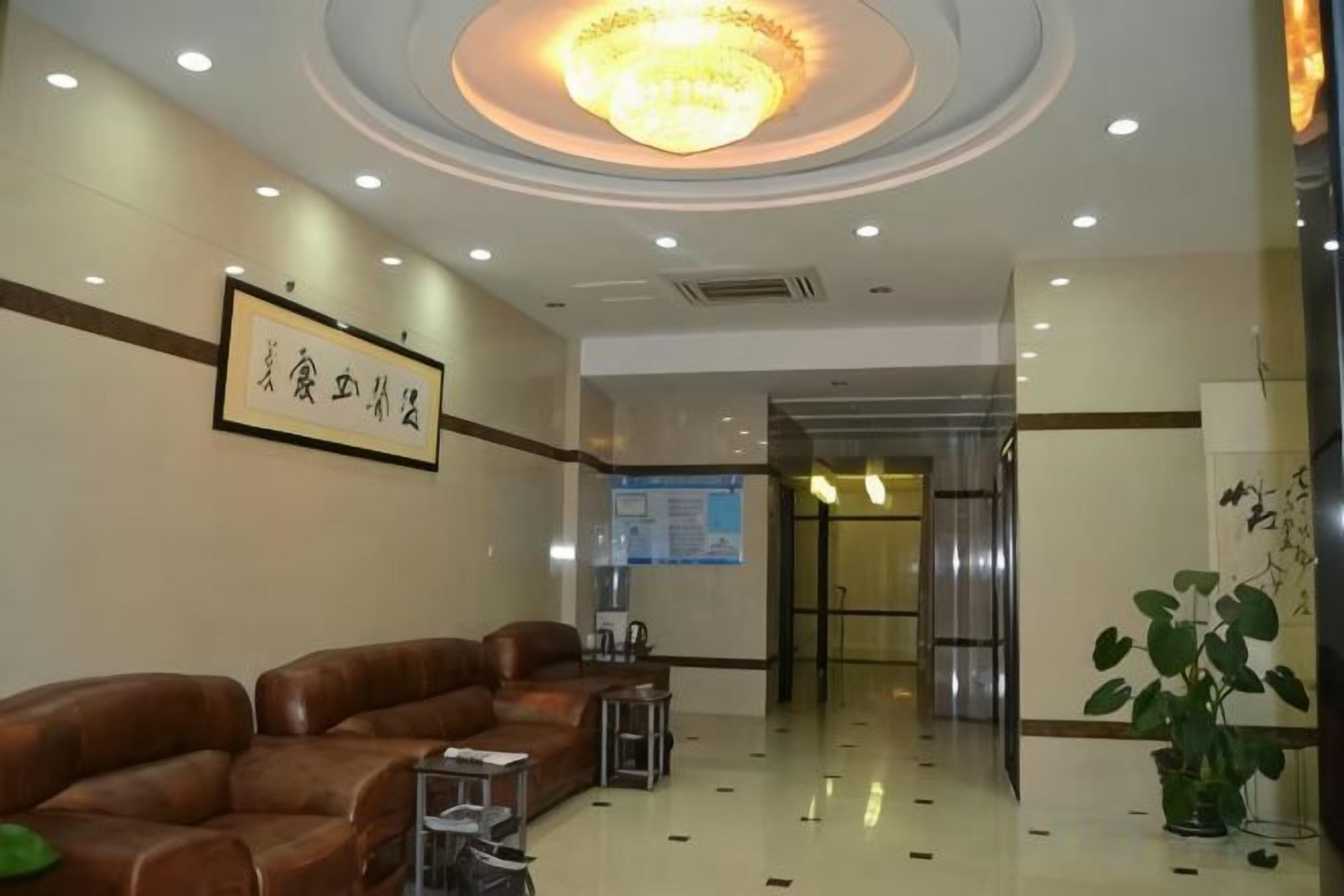 Un vestíbulo de hotel con mostrador de recepción, zona de estar y un candelabro.