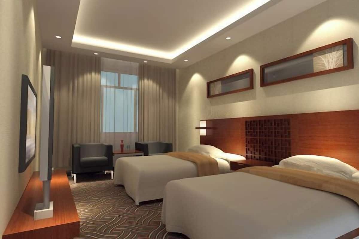 A hotel room with two beds, a desk, a chair, and a large window.