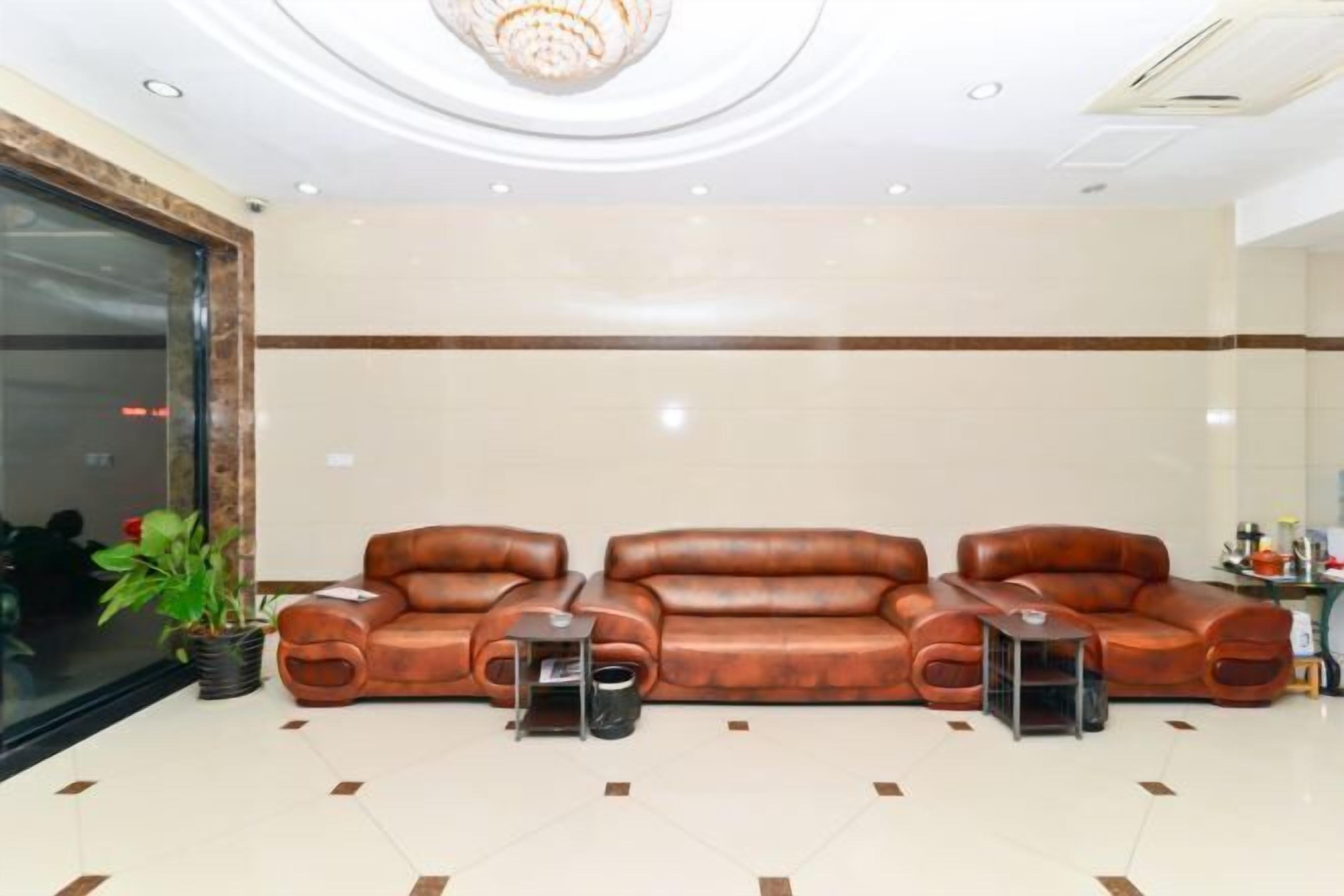 A lobby with a large seating area, a potted plant, and a reception desk.
