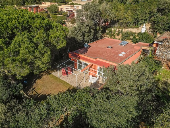 Relax in a spacious patio area surrounded by lush greenery, with large windows offering ample light.