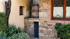A rustic building with a stone facade, a wooden barrel, and a window with lace curtains. - Cosy apartment in villa for 4 people with WIFI, terrace, pets allowed and panoramic view (Greve In Chianti)