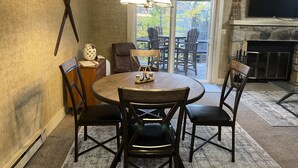 A dining area with a round table, four chairs, a chandelier, and a fireplace. - Relax and unwind Townhome in Snow Ridge Village at Jack Frost mtn in the Poconos (Lake Harmony)