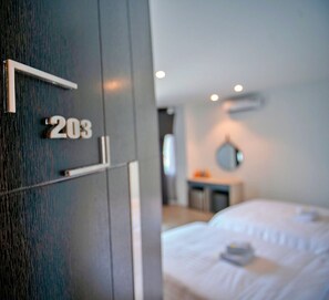 A modern hotel room with a large bed, a bedside table, and a mirror on the wall. -  S79 Mina Hotel (Tam Phuoc)
