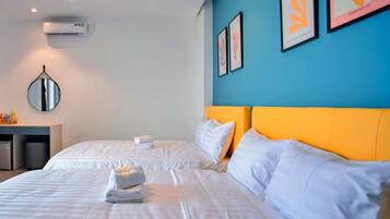 Ein Hotelzimmer mit zwei Betten, einer blauen Akzentwand und Kunstwerken.