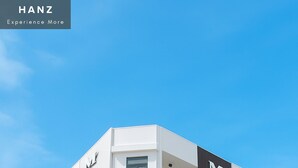 Un hotel de varios pisos con fachada blanca y un letrero vertical oscuro que dice "MINAHOTE".