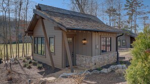 A single-story house with a stone foundation and a sloped roof. - Golf and Riverfront Cottage | King Bed | Group Availability (Mineral Bluff)