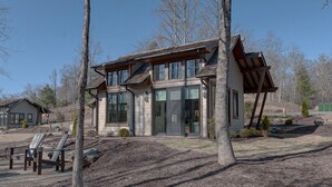 Une maison moderne à deux étages, dotée de grandes fenêtres et d’un porche abrité.