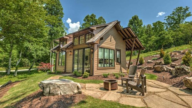 A modern house with a large deck, stone pathway, and outdoor seating area. - Golf and Riverfront Cottage | King Bed | Group Availability (Mineral Bluff)