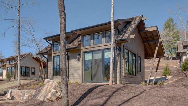 A modern two-story house with large windows and a sloped roof. - Golf and Riverfront Cottage | King Bed | Group Availability (Blue Ridge)