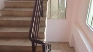 A staircase with a metal handrail leading to a landing. - iROOMZ City Lite Lodge (Nizamabad)